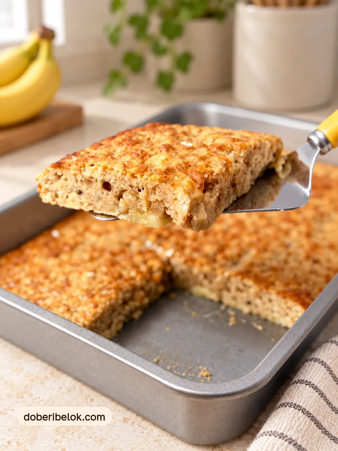 Лопатка с жёлтой ручкой поднимает кусок панкейка из формы
